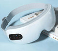 The Bluetooth Music Eye Massager resting on a couple of books with a blue background